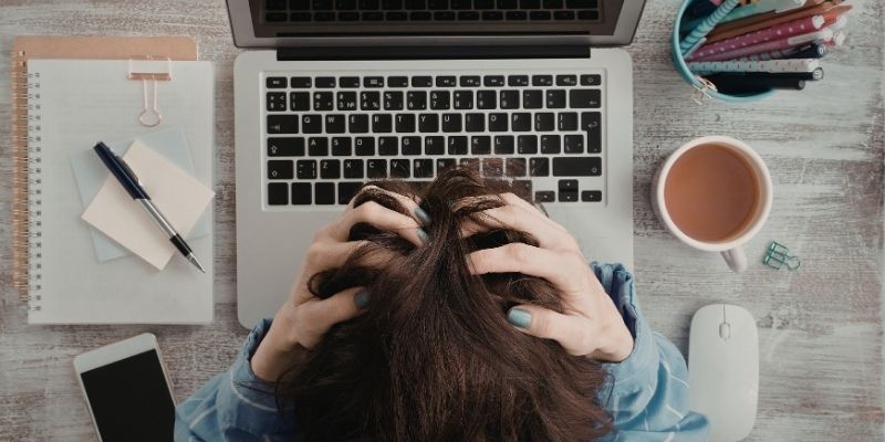 Personne débordée au travail prenant un moment de pause pour prioriser ses tâches